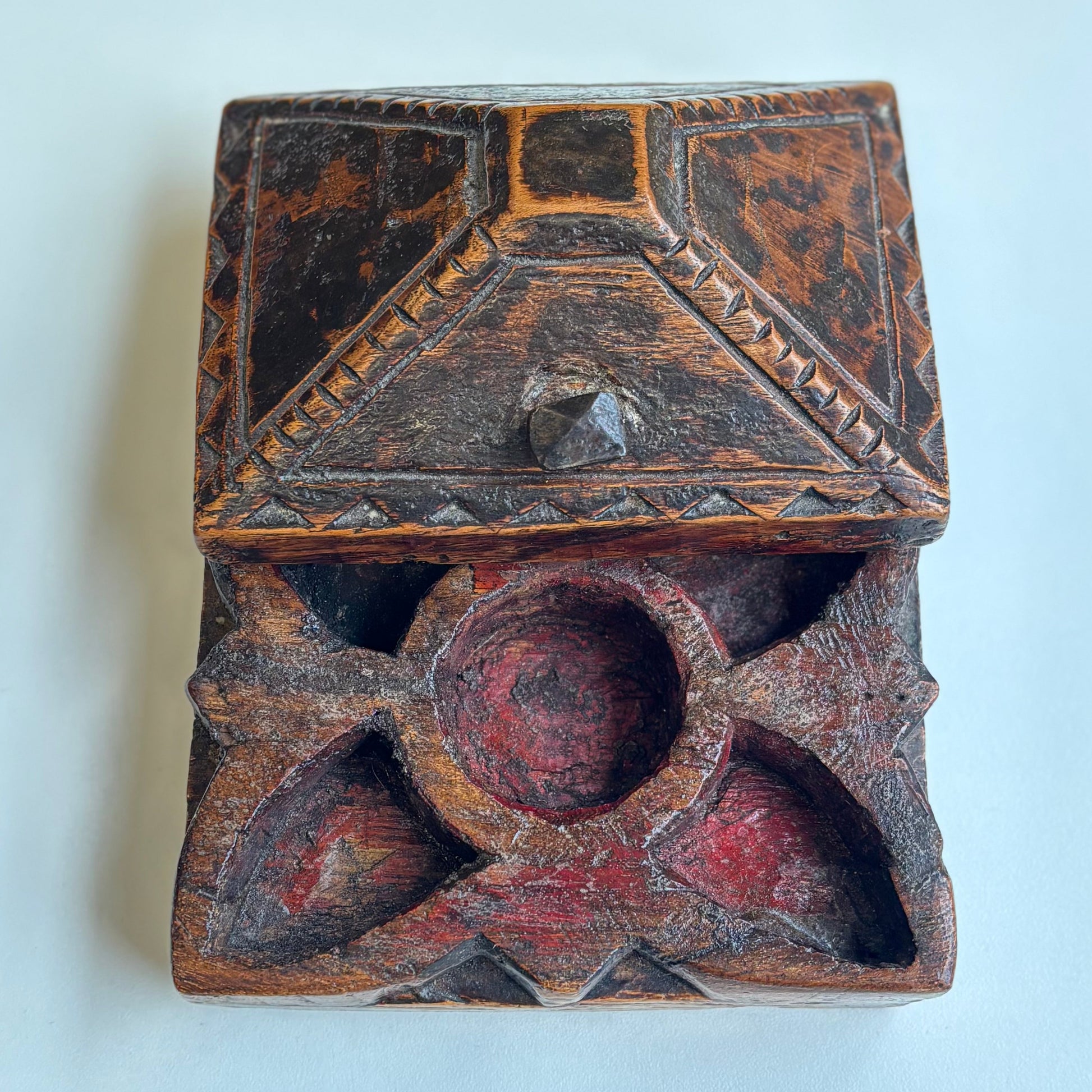 Decorative wooden box with geometric patterns on a light blue background