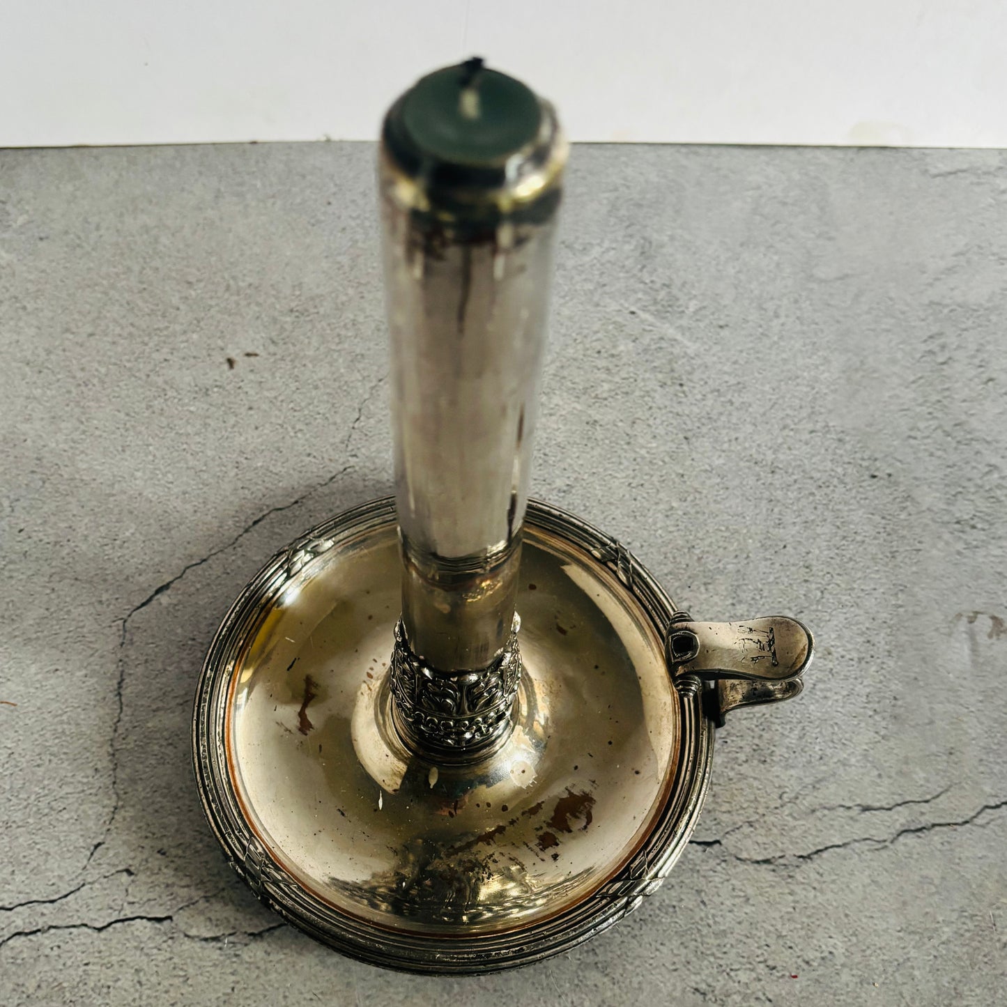 Silver candlestick holder on a textured grey surface