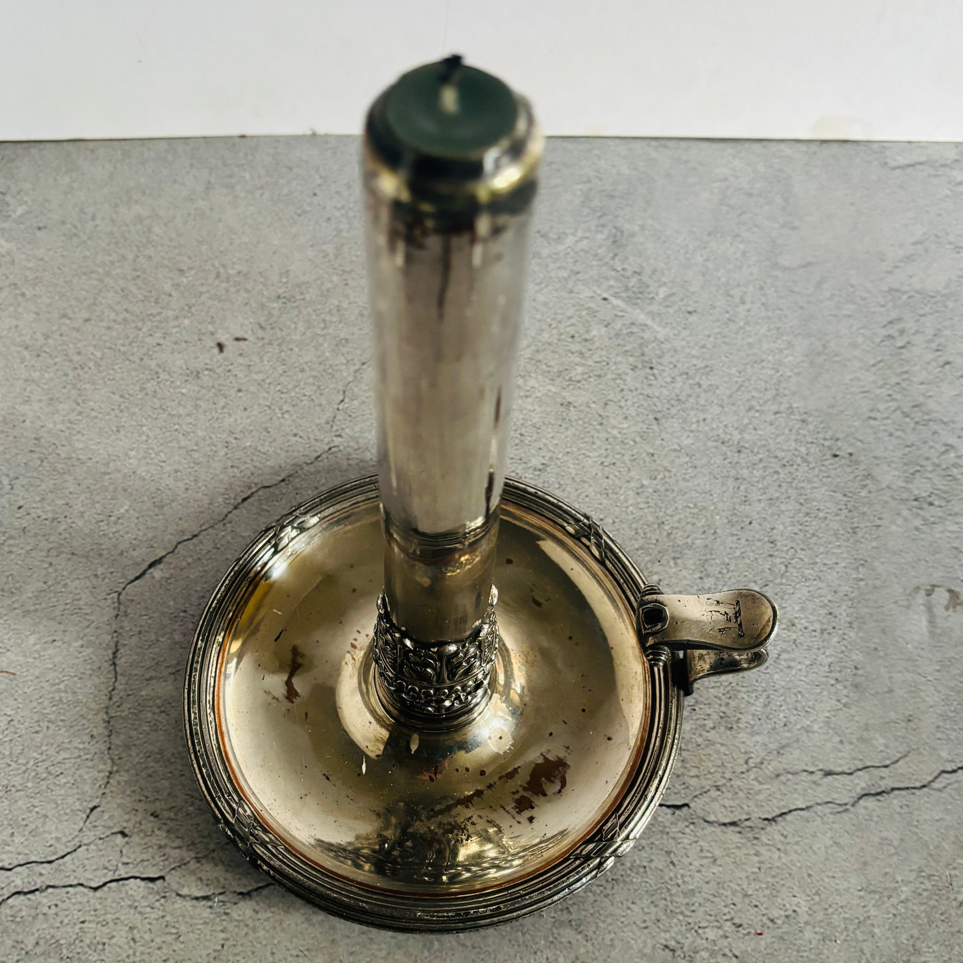 Silver candlestick holder on a textured grey surface
