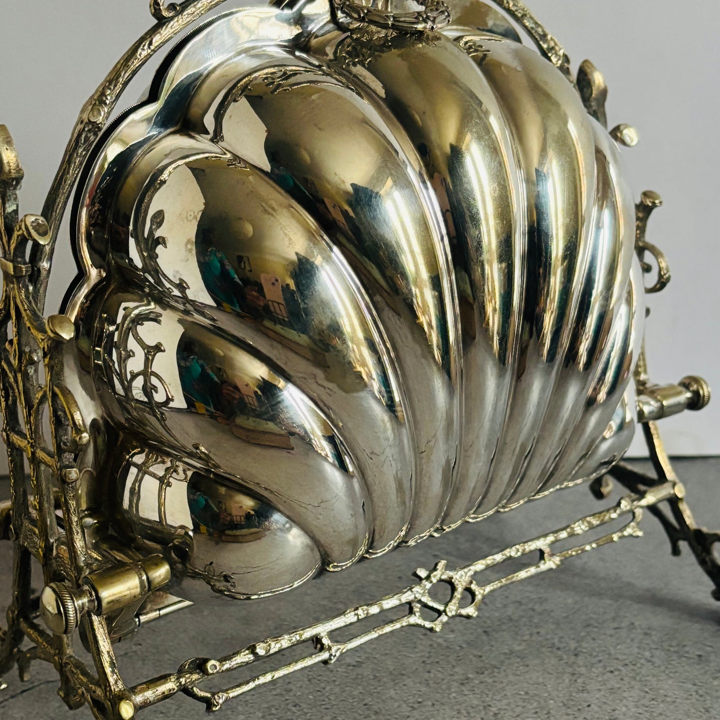 Decorative antique silver shell with intricate design on a gray background