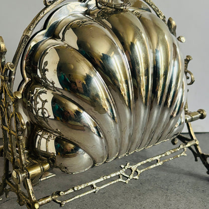 Decorative antique silver shell with intricate design on a gray background