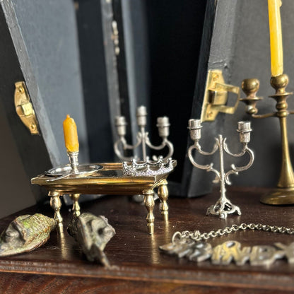 Collection of vintage-style candle holders and decorative items on a wooden surface.