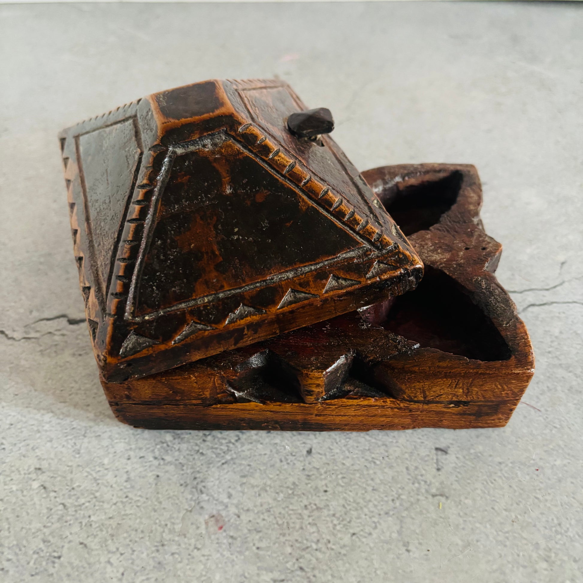 Wooden box with intricate carvings on a gray surface