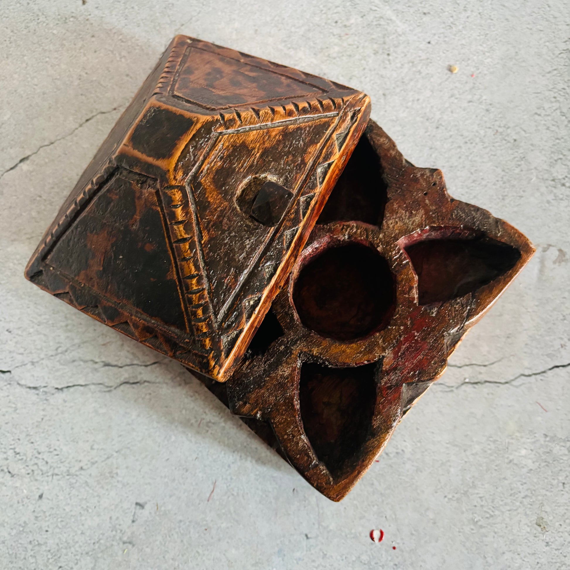 Vintage wooden box with intricate carvings on a gray surface