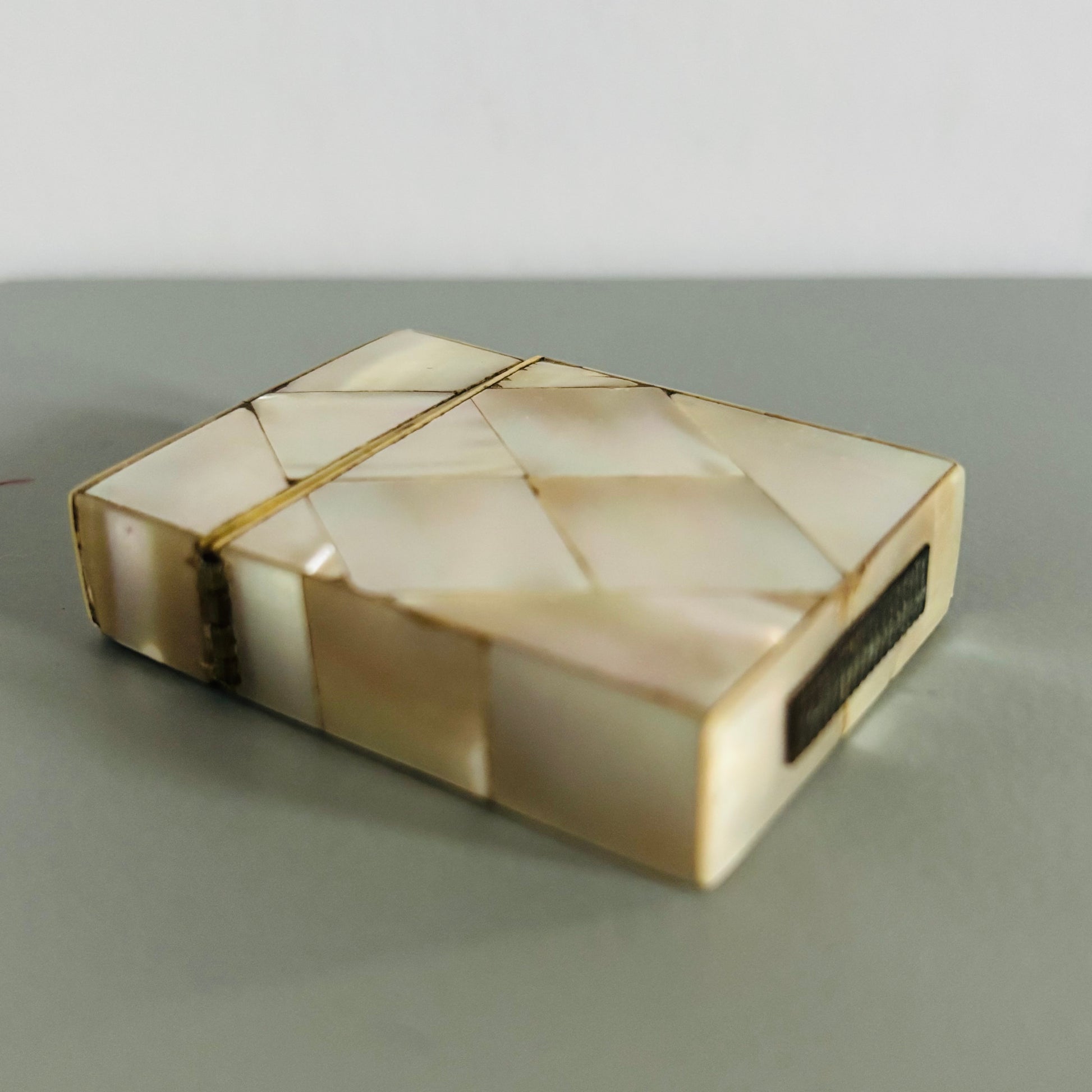 Rectangular decorative mother of pearl vesta  with geometric pattern on a grey background