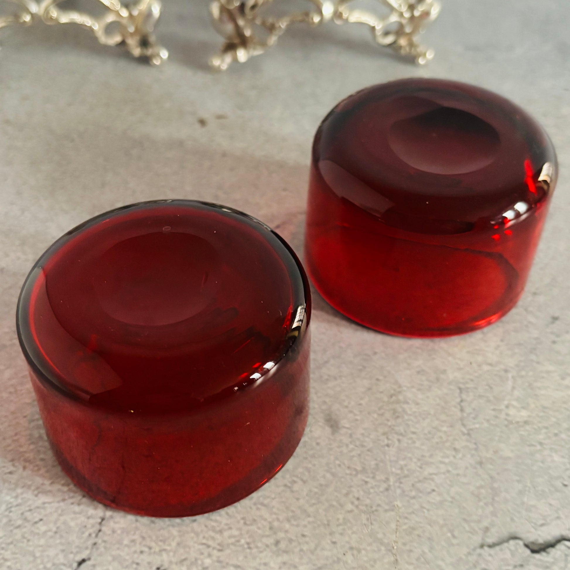 Two red glass knobs on a textured surface