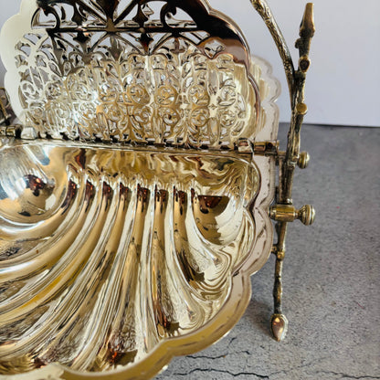 Decorative silver dis with intricate designs on a grey surface