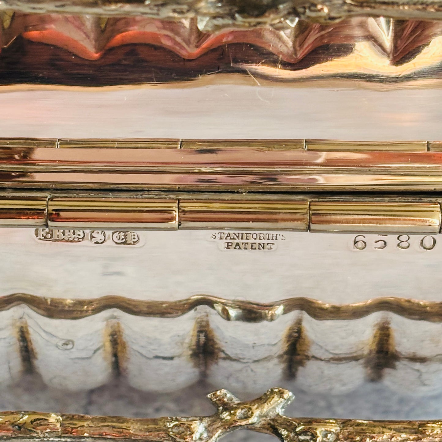 Close-up of a Antique Biscuit Warmer | Folding Biscuit Box with engraved hallmarks and design details.