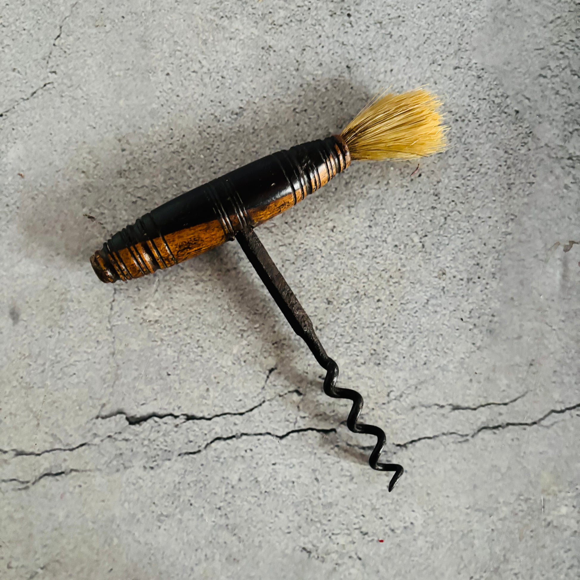 Corkscrew with a brush on a textured concrete surface