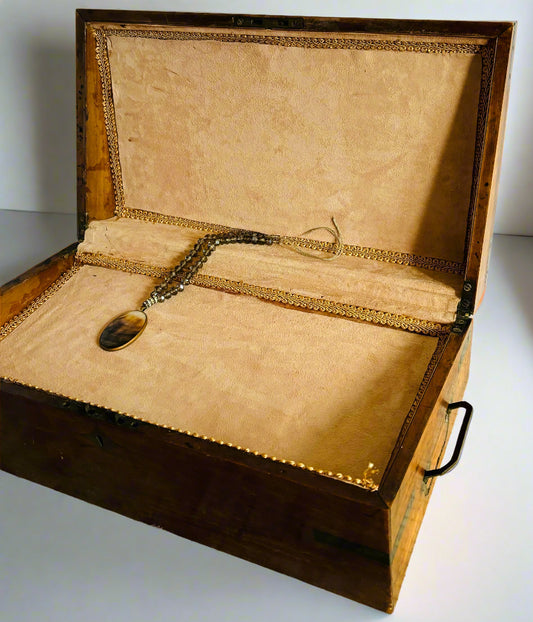 Open wooden display box with a necklace on a white background