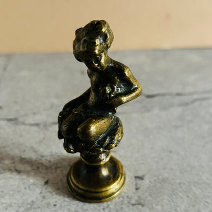 Bronze statue of a seated figure on a marble surface