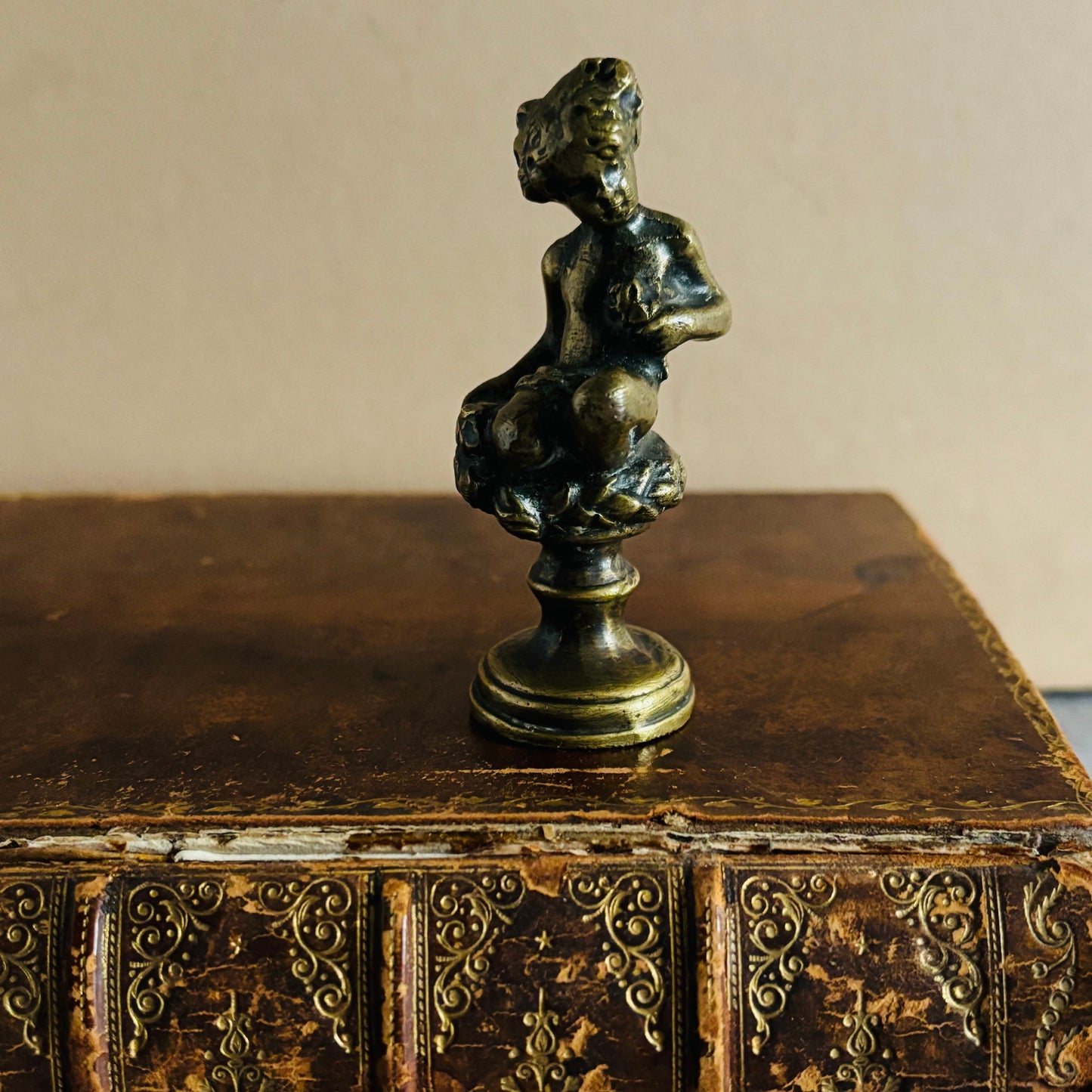 Bronze sculpture of a nude figure on an ornate wooden box