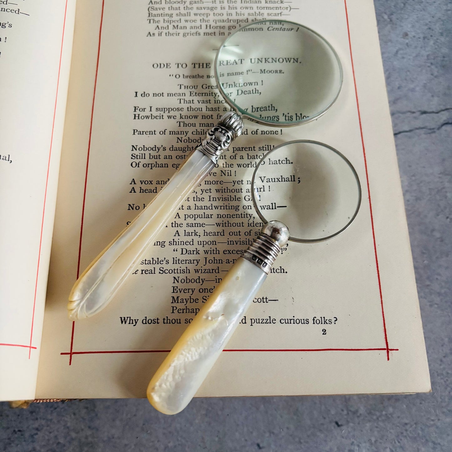 Two vintage magnifying glasses on an open book with text.