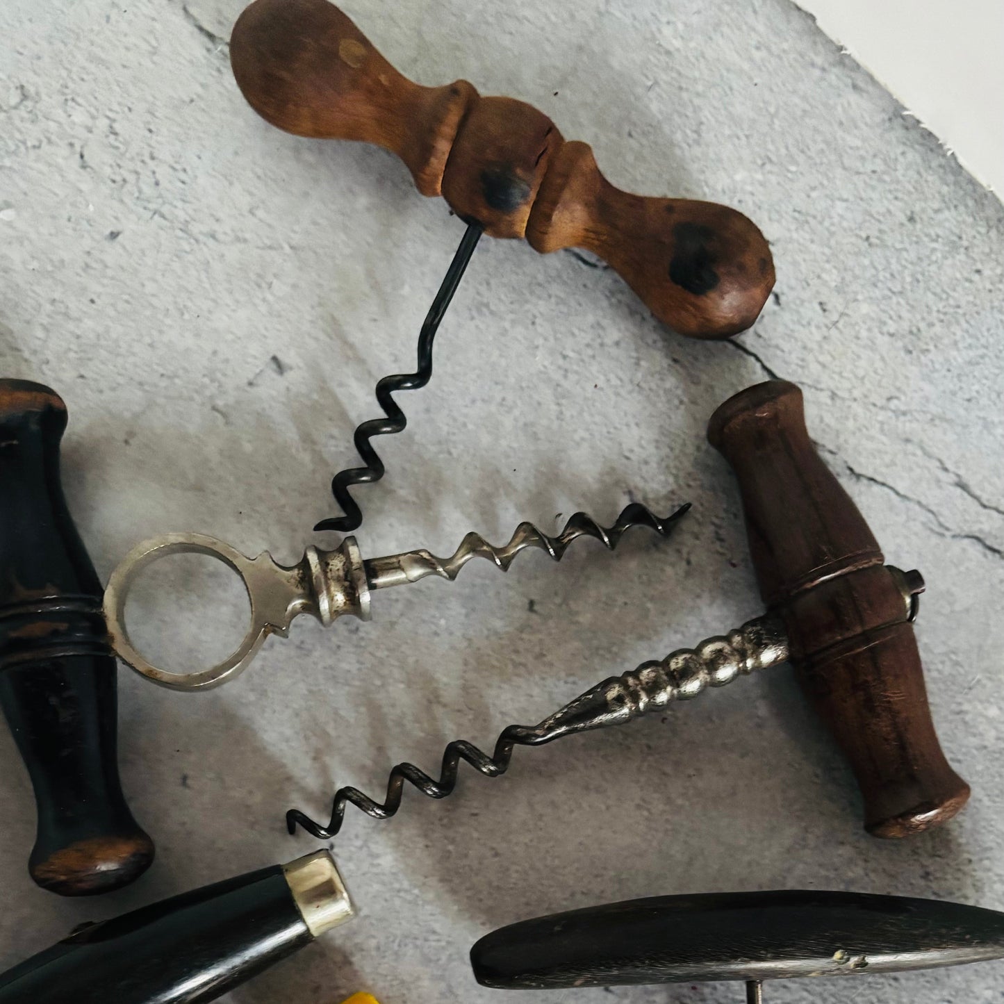 Vintage corkscrews with wooden handle on a textured surface