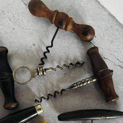 Vintage corkscrews with wooden handle on a textured surface