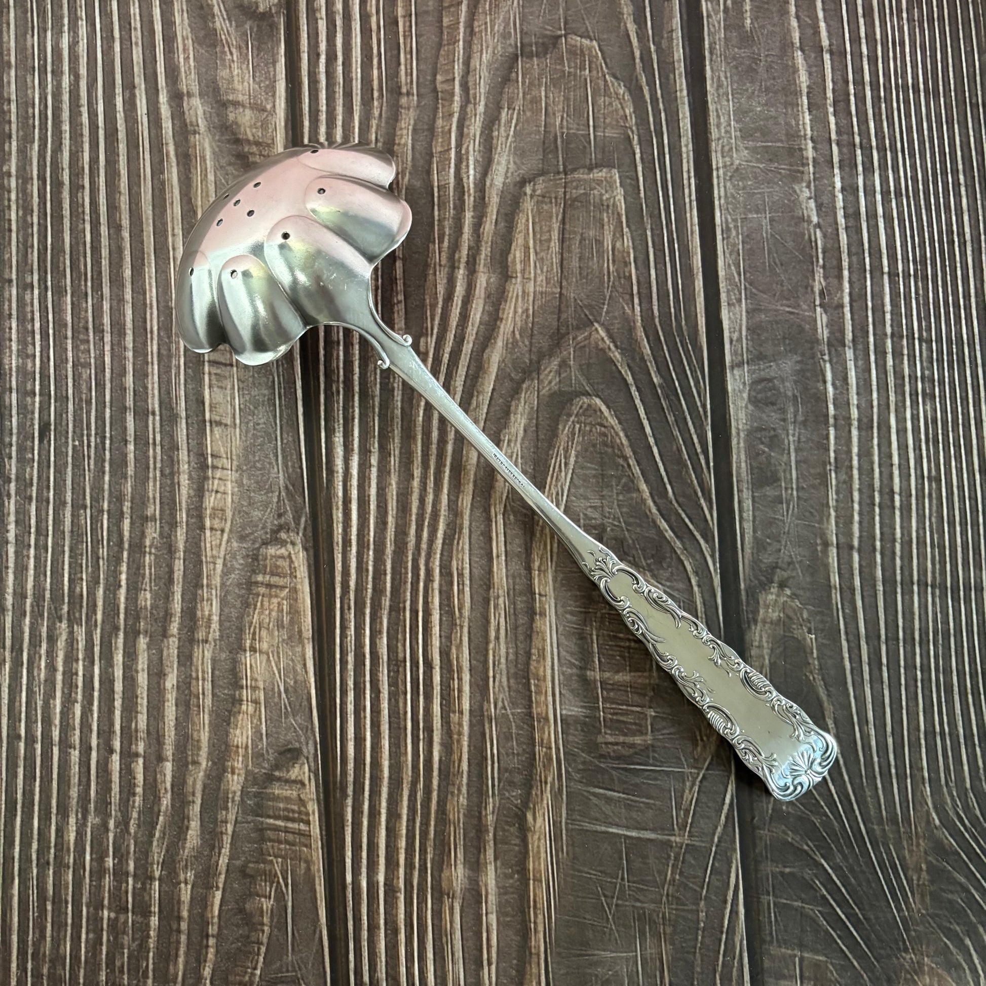 Decorative silver ladle on a wooden surface