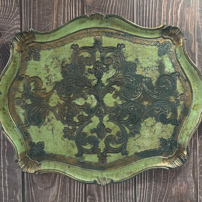 Decorative metal plaque with intricate designs on a wooden surface