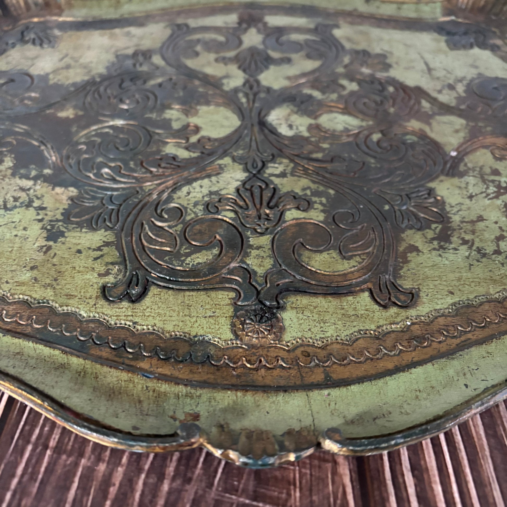 Decorative metal surface with intricate patterns on a wooden background