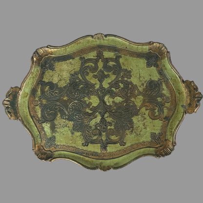Decorative green and gold metal plate with intricate patterns on a gray background