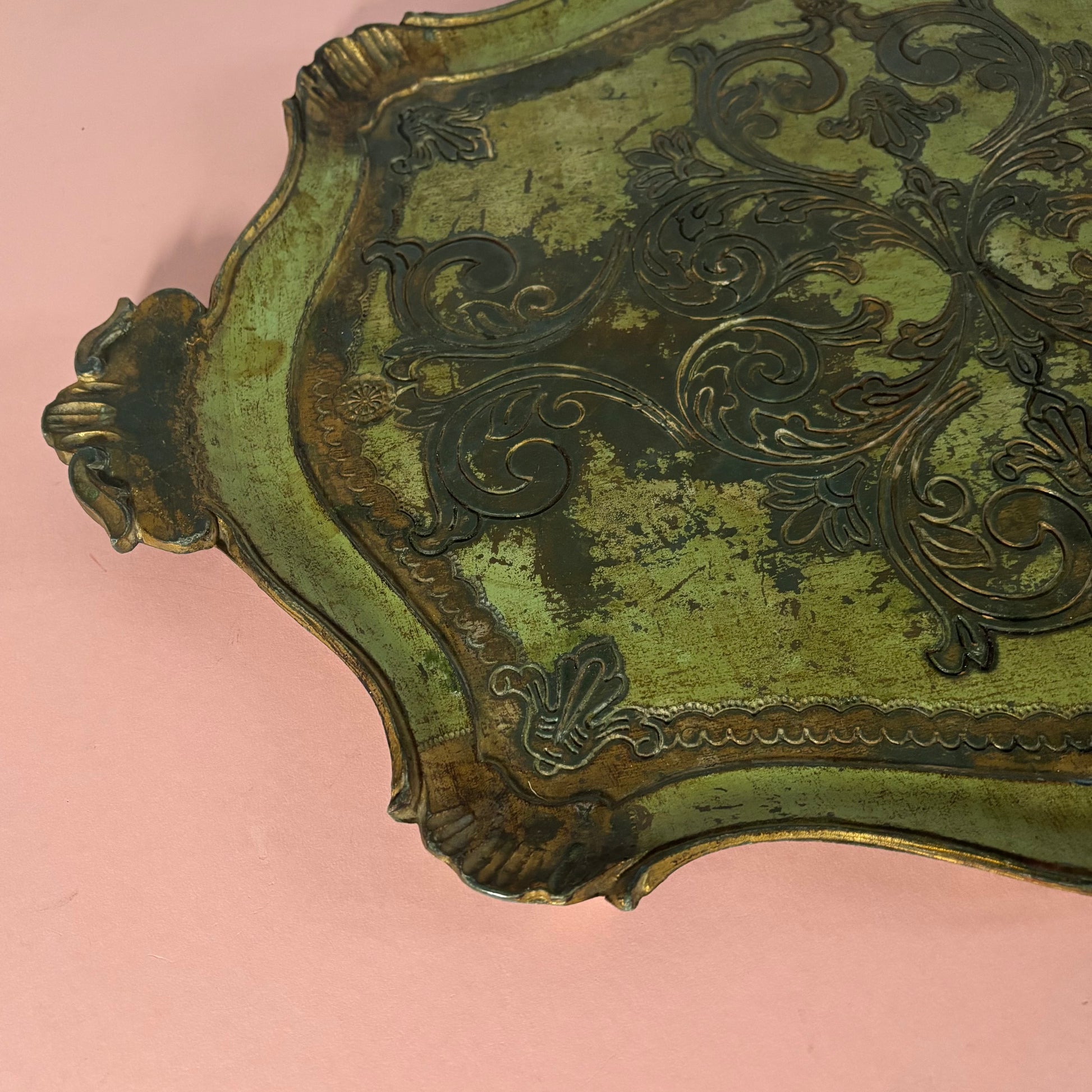 Decorative metal object with intricate patterns on a pink background