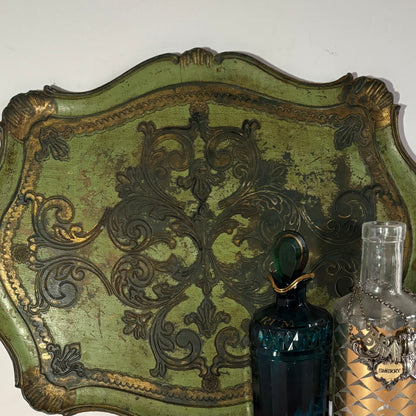 Decorative wall plaque with intricate designs next to a blue bottle and a glass container.