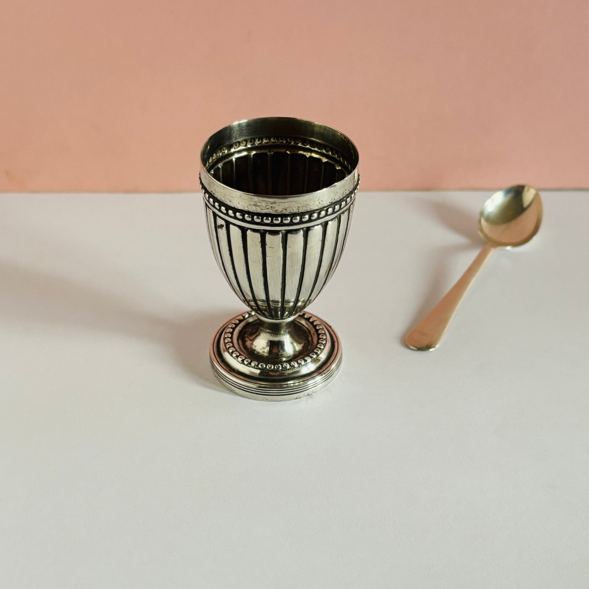 Decorative silver cup with a pink background