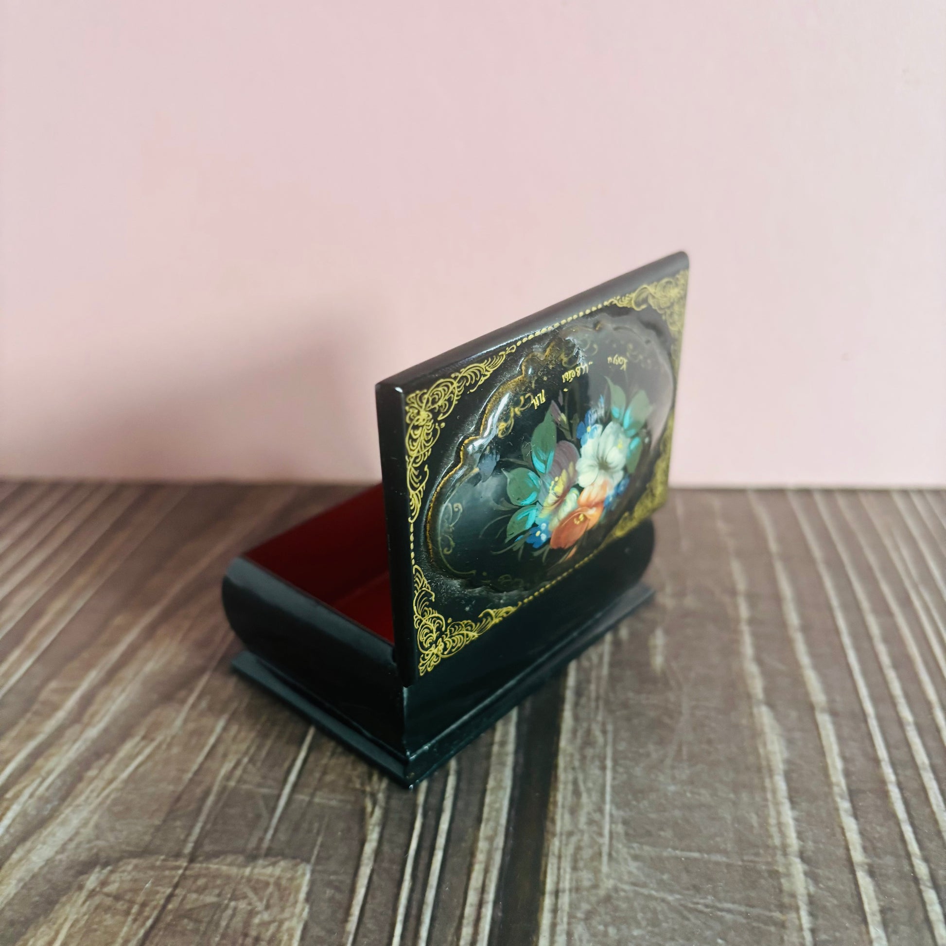 Decorative box with floral design on a wooden surface