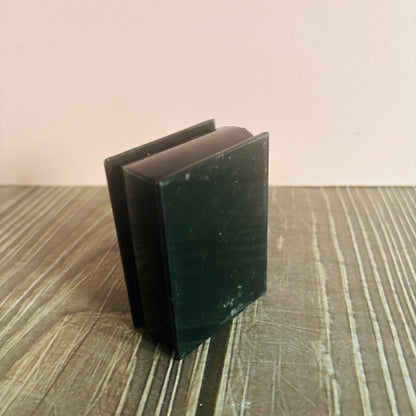 Black rectangular object on a wooden surface with a beige background