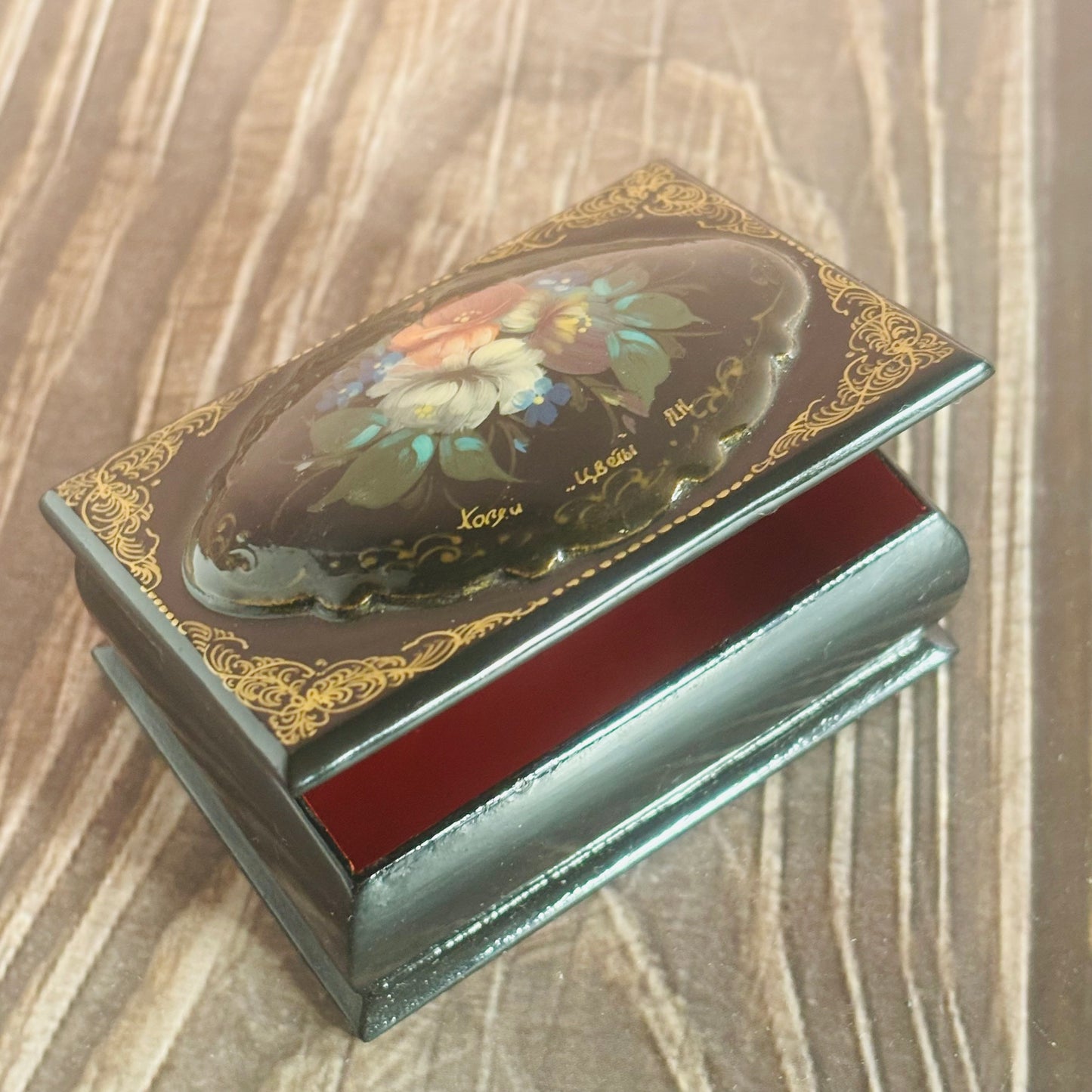 Decorative jewelry box with floral design on a wooden surface