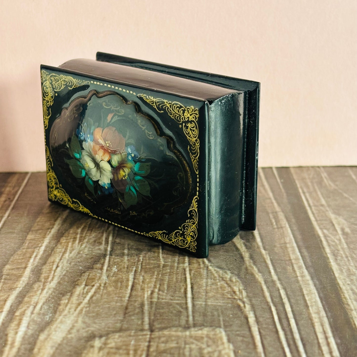 Decorative black book with floral design on a textured surface